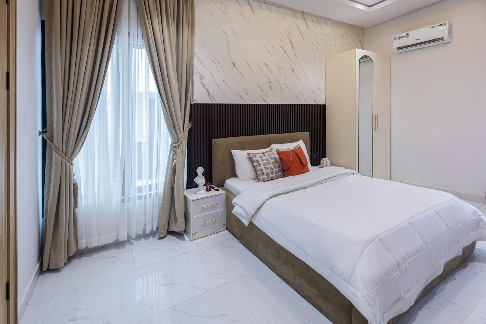 Bedroom with marble feature wall, Apartment Alpha, Nimbus Nook shortlet in Ikeja GRA