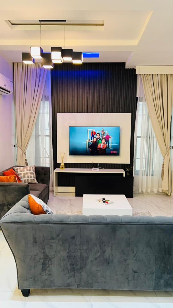 Living room with feature TV wall, Apartment Alpha, Nimbus Nook shortlet in Ikeja GRA