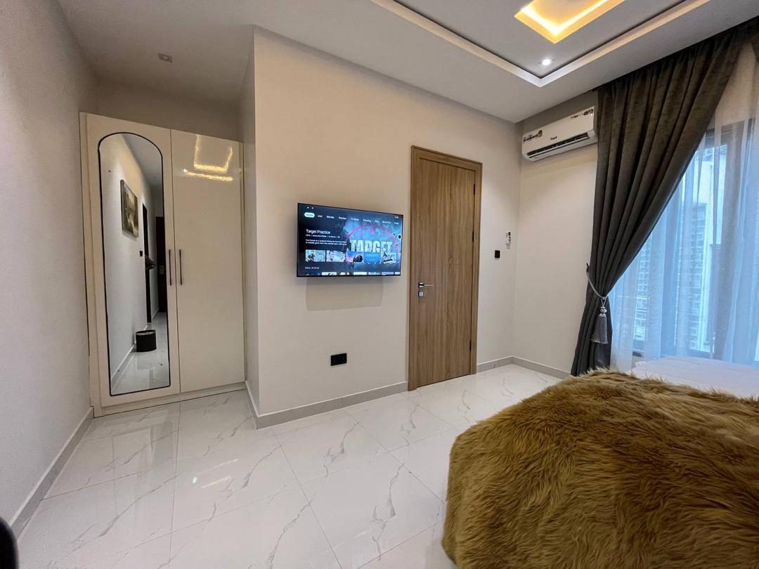 Bedroom with smart TV and wardrobe, Apartment Bravo, Nimbus Nook Ikeja GRA