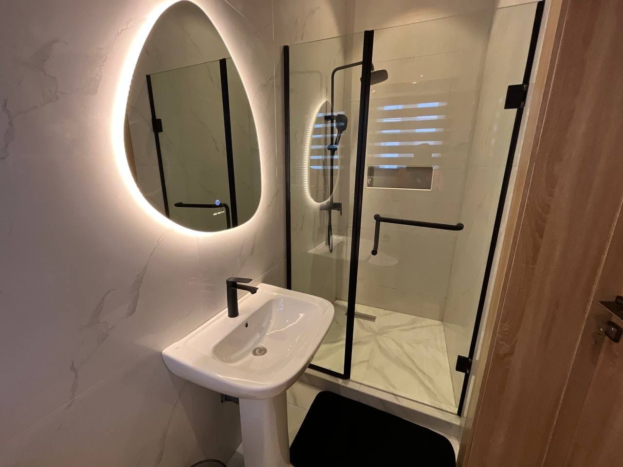 En-suite bathroom with illuminated mirror, Apartment Charlie, Nimbus Nook Ikeja GRA