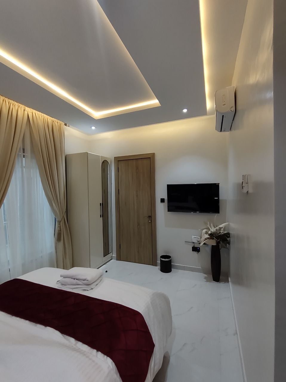 Bedroom with wardrobe and TV, Apartment Charlie, Nimbus Nook Ikeja GRA