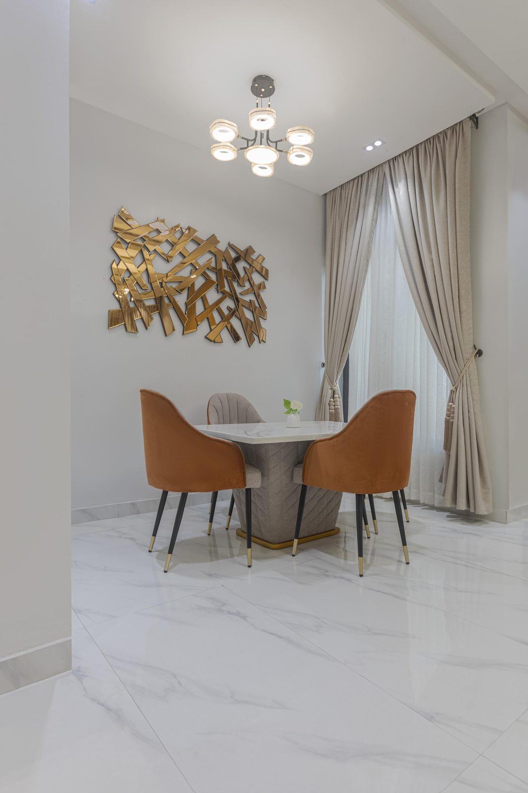 Dining area with gold mirror art, Apartment Charlie, Nimbus Nook shortlet in Ikeja GRA