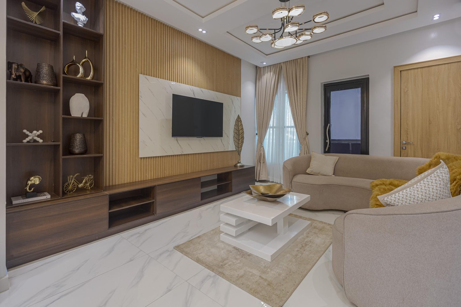 Living room with fluted wood feature wall, Apartment Charlie, Nimbus Nook shortlet in Ikeja GRA